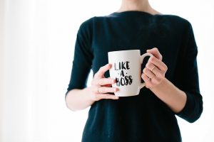 Woman holding mug with the phrase 'like a boss' printed on mug